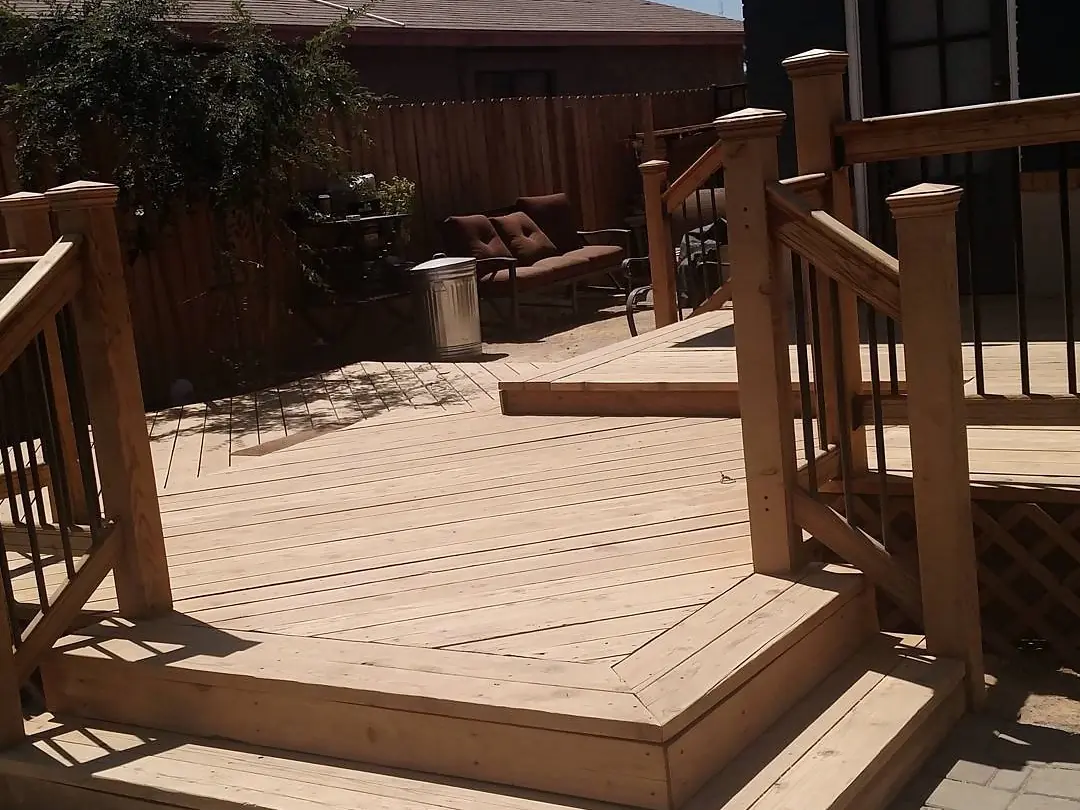 Unfinished natural-wood deck and railings before the red and white coating work.